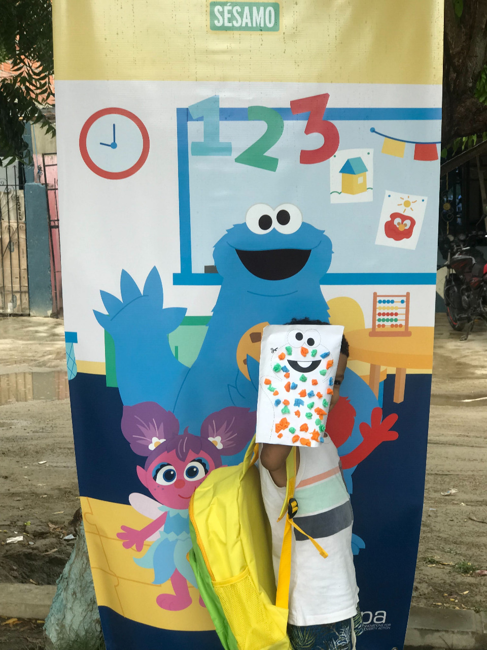 Enfant devant une bannière avec dessin d'Elmo