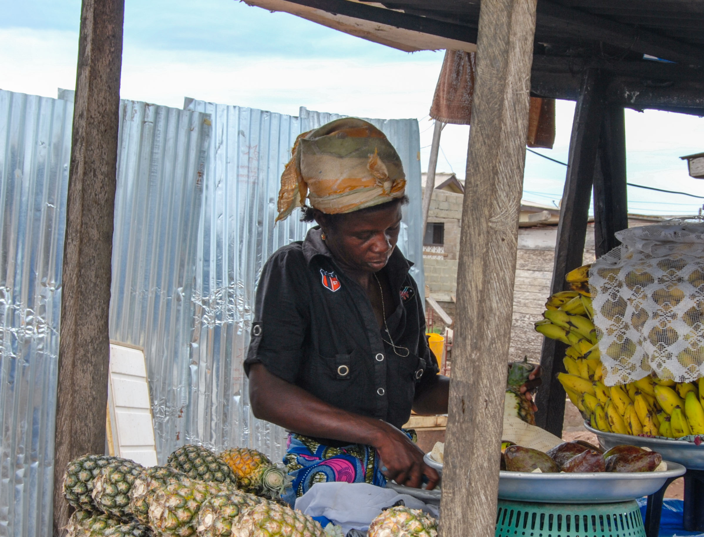 Une femme vend des ananas et des bananes sur un marché de produits frais à Elmina, au Ghana. © 2015 Margus Vilbas / Shutterstock.com