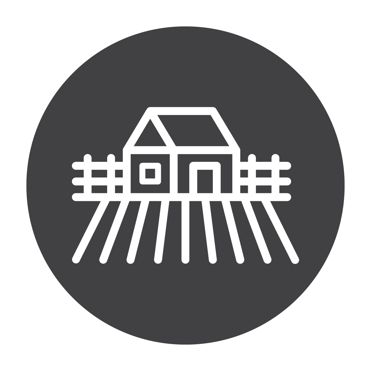 Icon of a house surrounded by a picket fence with a tilled field of farmland in front