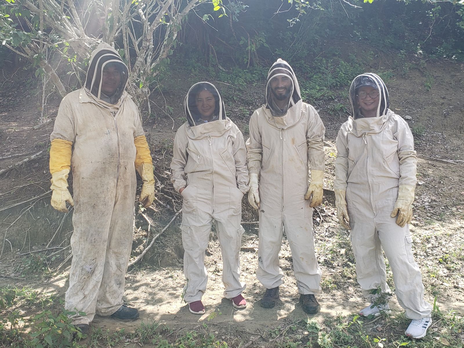 Dos jóvenes líderes en Montes de María, que gestionan el proyecto apícola que brinda oportunidades económicas, se ven con los miembros del equipo de ConsultIPA Camilo Rodríguez y Luisa Mazora (IPA Colombia/Jorge Forero)