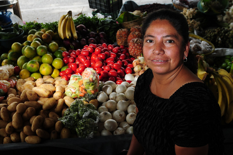 A woman attends her produce post in a market in zone 3, Guatemala City. Guatemala. Photo: Maria Fleischmann / World Bank