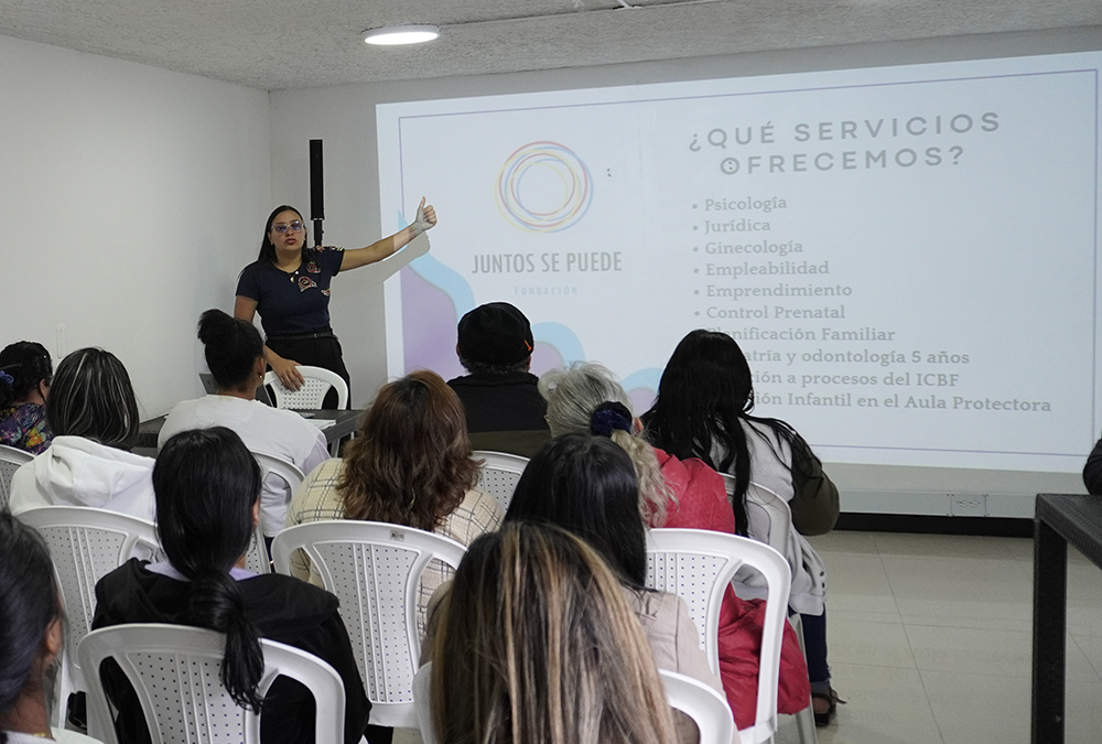 Juntos se Puede event where a woman is giving a presentation on what services the organization offers