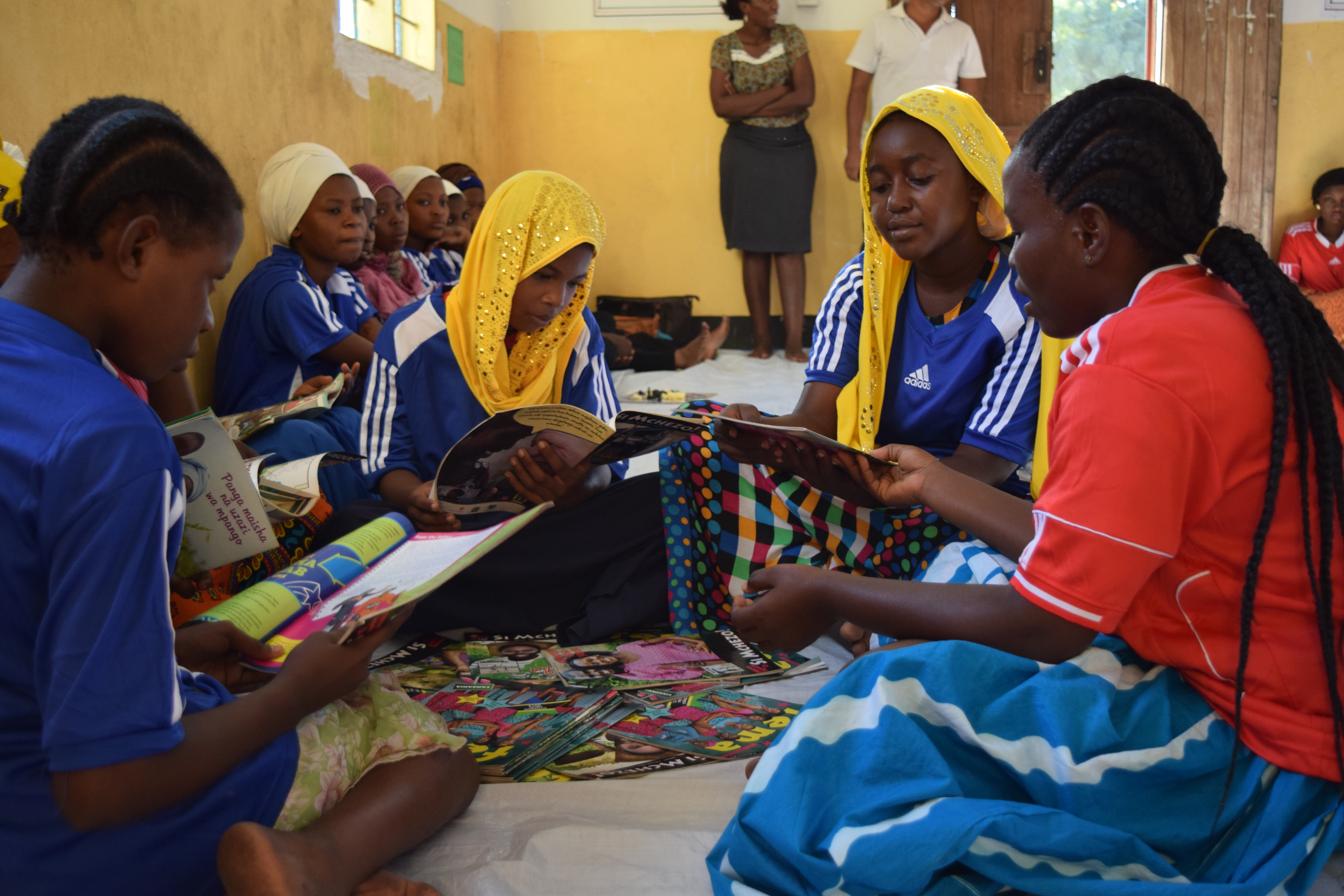 Girls in a youth club in Tanzania reading books on social issues as part of BRAC's Empowerment and Livelihood for Adolescents (ELA) program.