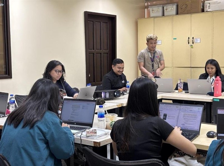 Participants sitting at desks working on their laptops