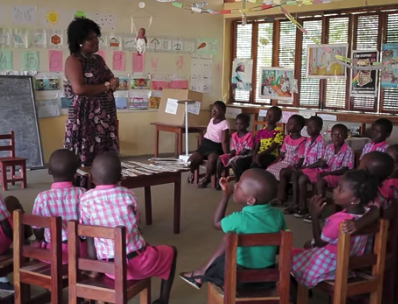A still image of a teacher in front of her kindergarten classroom, from a film about this project featured on the IPA project webpage..