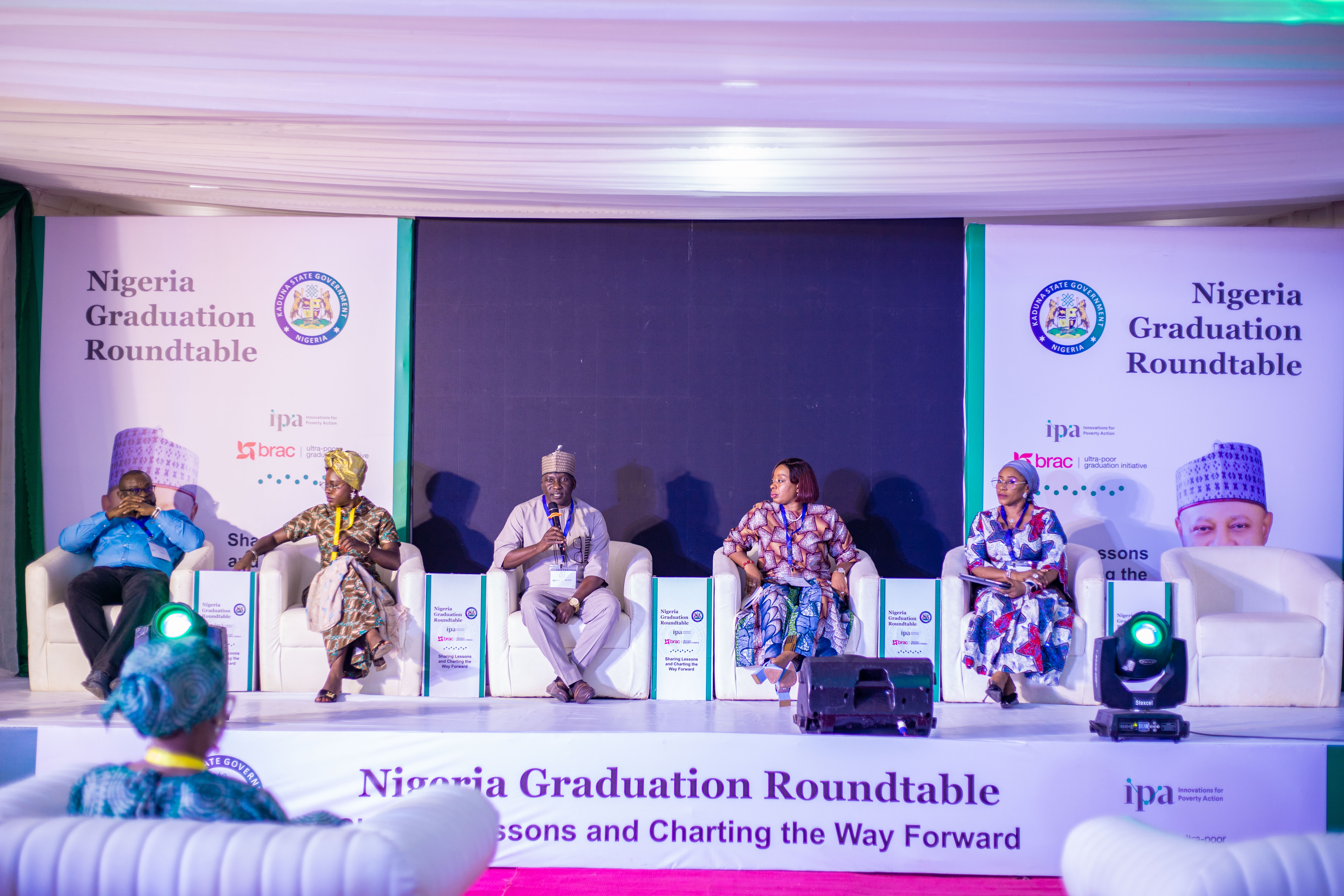 Panelists speaking on the event stage