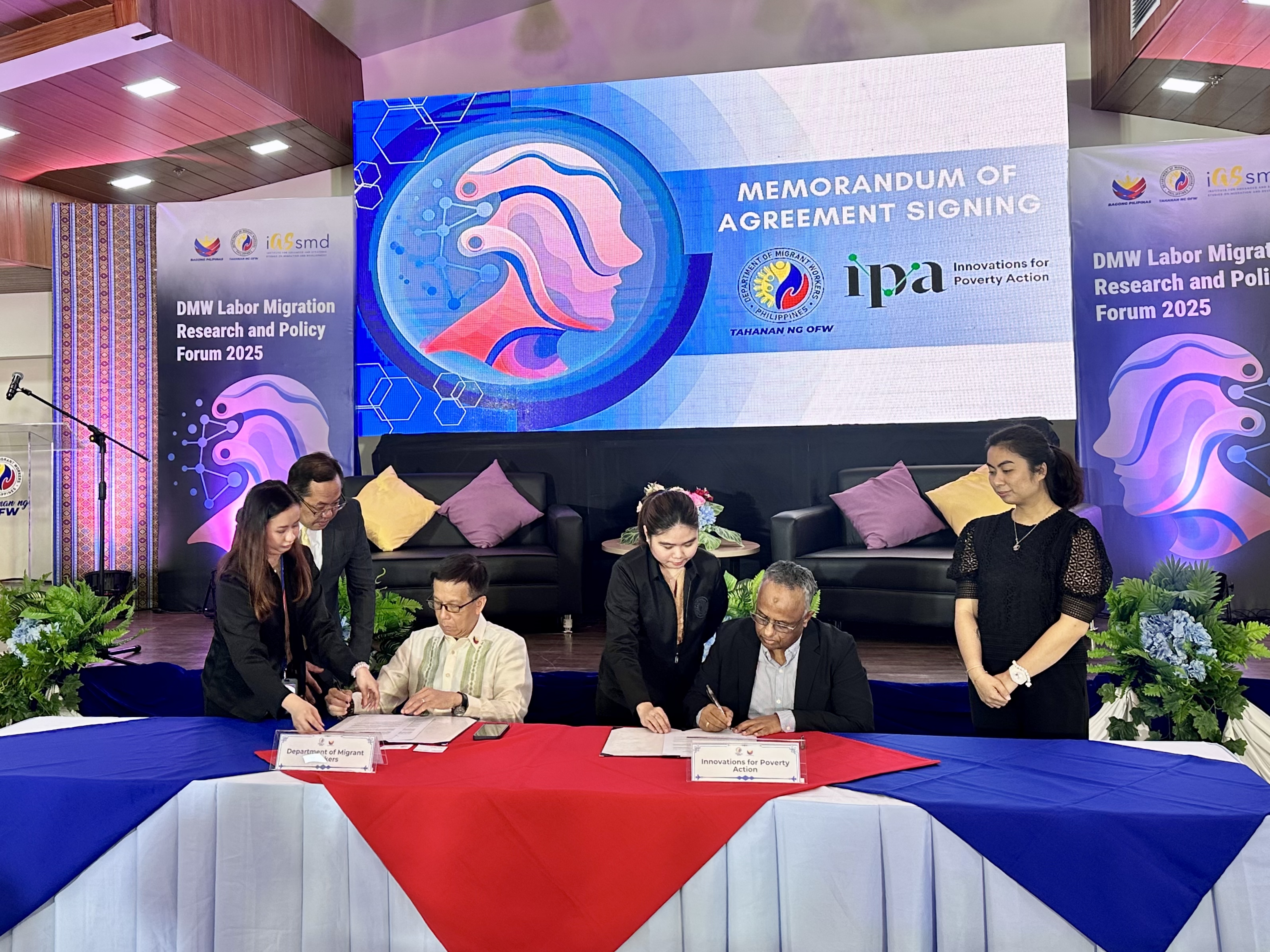 Photo of representatives from IPA and DMW sitting at a table signing MOU documents