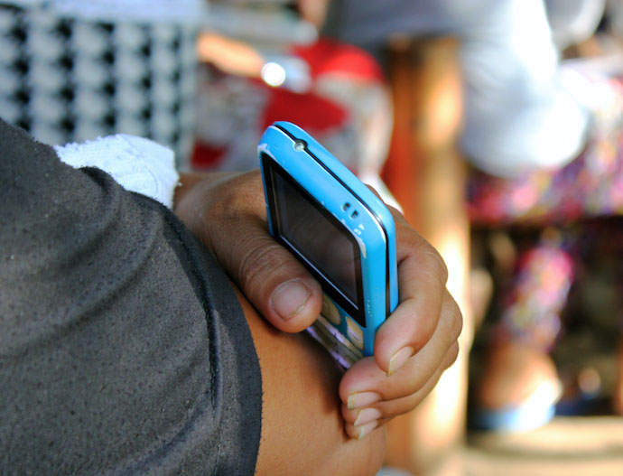 A person holding a mobile phone in the Philippines. © 2015 David Batcheck