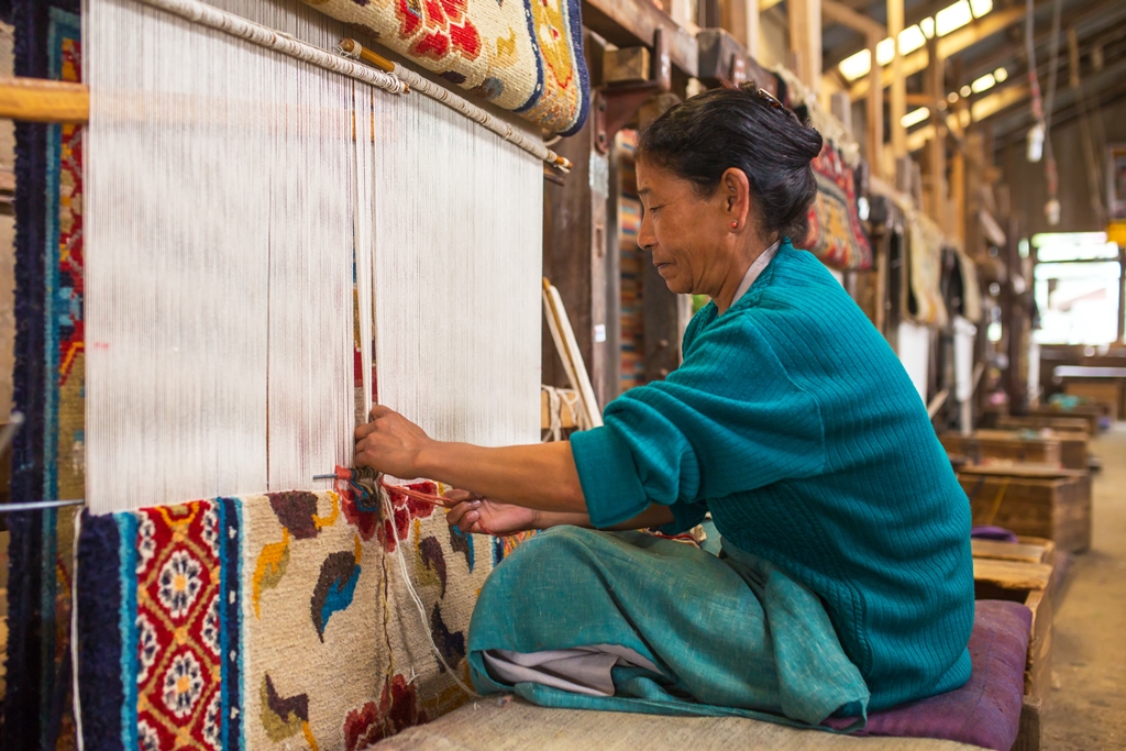 Une femme tibétaine travaille comme tisserande dans l'atelier de tapis du Centre d'entraide pour les réfugiés tibétains à Darjeeling, en Inde.