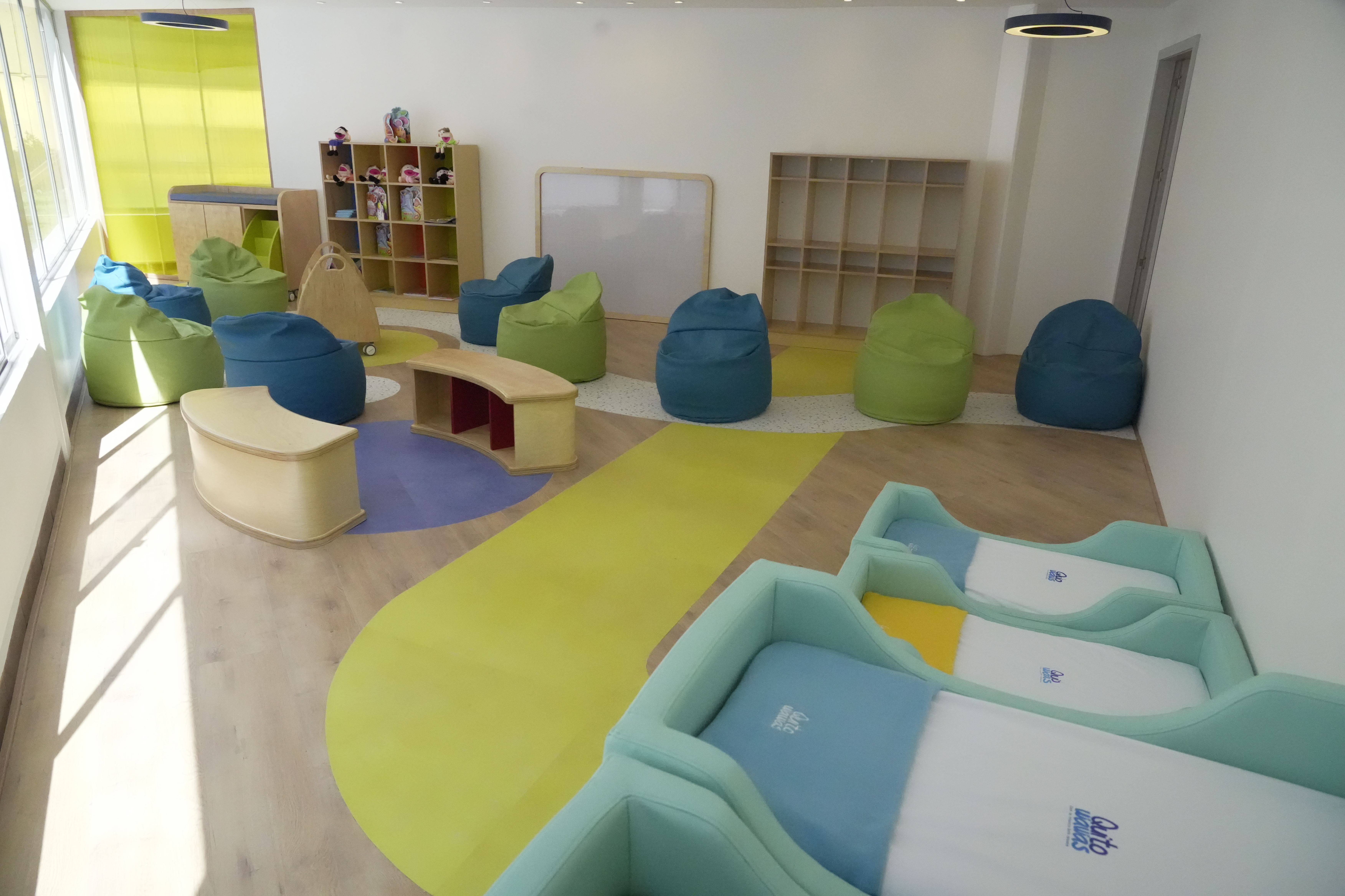 Photo of a playroom for young children furnished with yellow, green, and blue furniture
