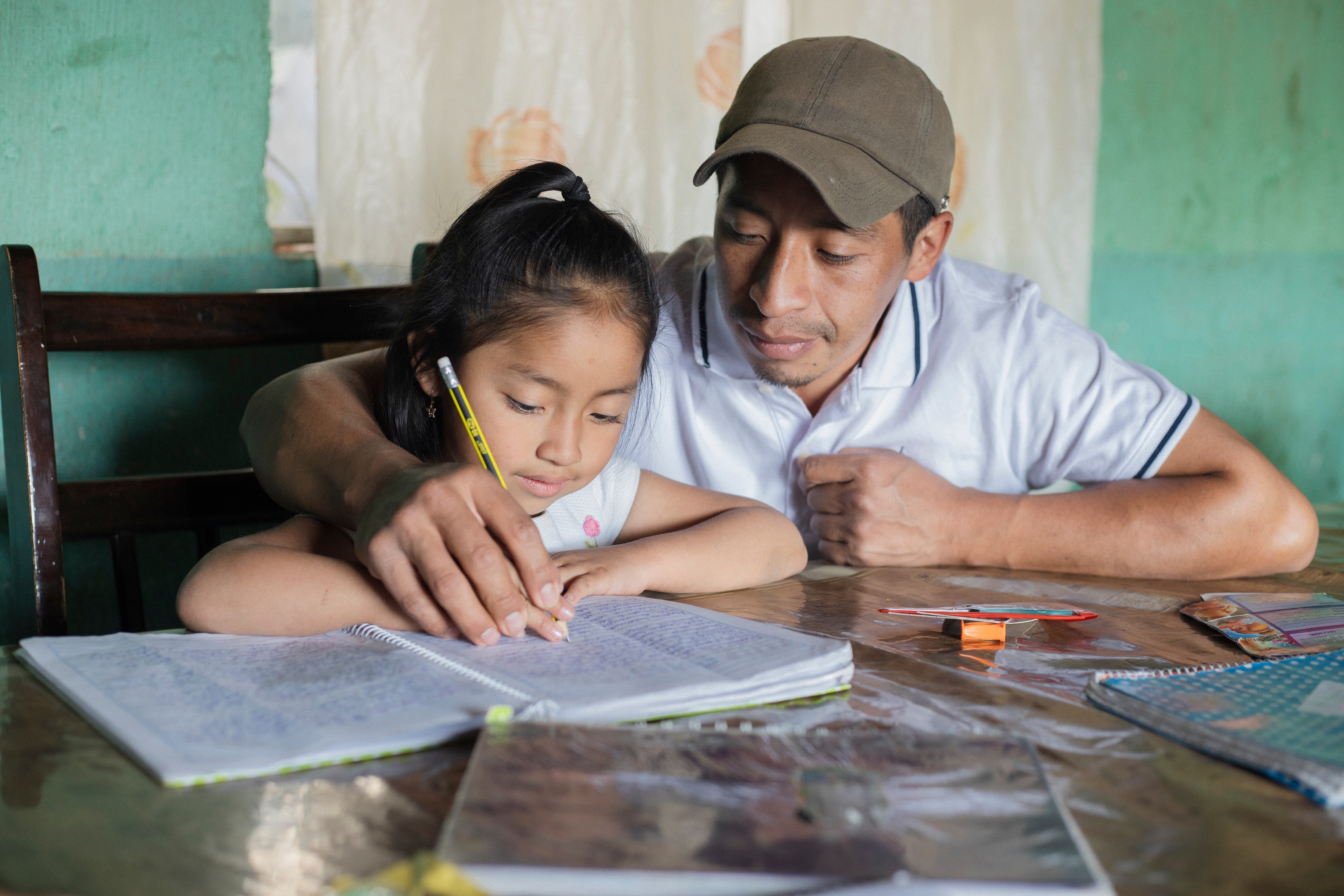 A dad helping his young girl with homework