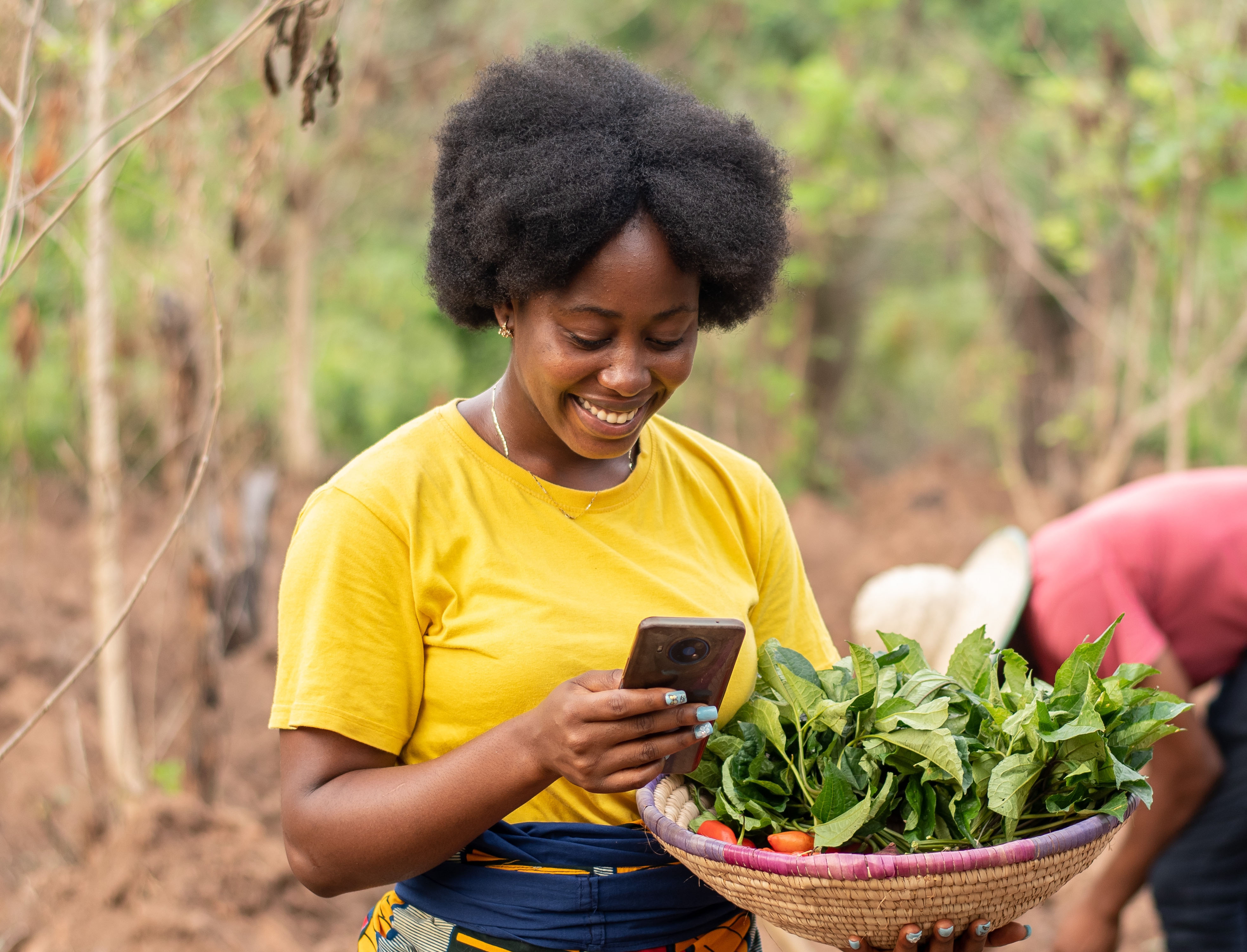 A farmer uses her smartphone. © 2023 i_am_zews / Shutterstock.com