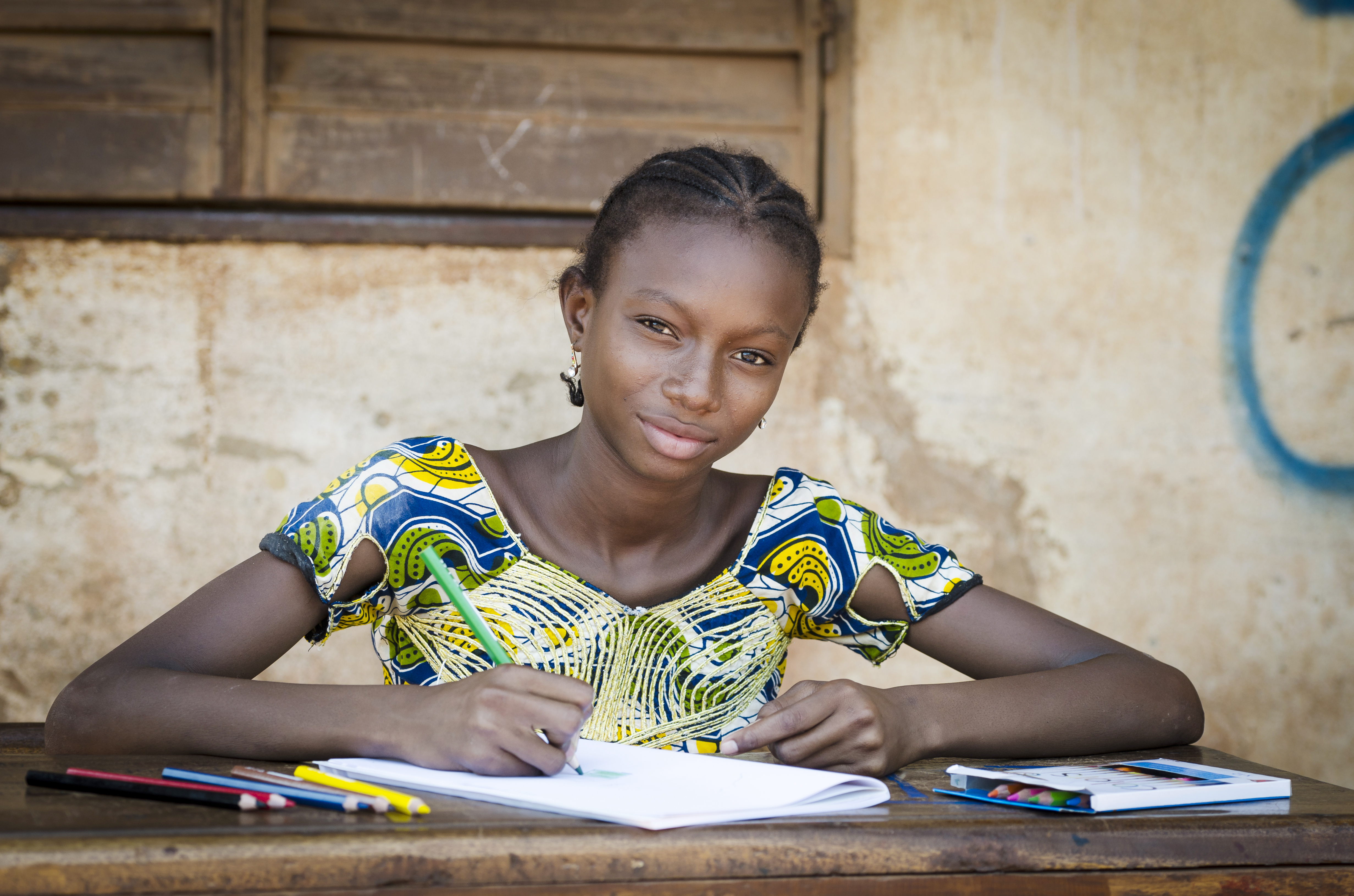 A schoolgirl poses for a photo in an educational setting. © 2023 Riccardo Mayer/Shutterstock.com