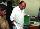A tax collector reviews documentation from a citizen in Punjab, Pakistan