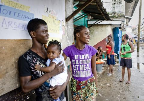 Des hommes, des femmes et des enfants se tiennent dans une rue au Libéria. © 2010 Glenna Gordon