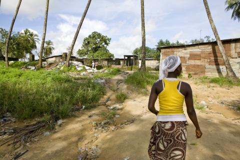 Une photo d'une jeune femme marchant au Libéria, le dos tourné à l'appareil photo. © 2010 Glenna Gordon