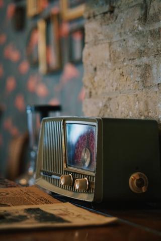 Une photo d'une radio noire et argentée sur une table en bois marron. © 2020 Nacho Carretero Molero sur Unsplash