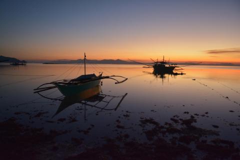 Two boats on the water in Palawan, Philippines. This is not a depiction of a confirmed instance of human trafficking. © 2018 Konrad Binder on Unsplash