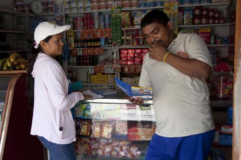 A photo of a woman talking to a man in a shop. © 2015 Paul Smith