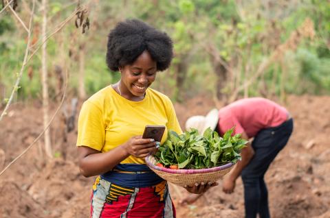 A farmer uses her smartphone. © 2023 i_am_zews / Shutterstock.com