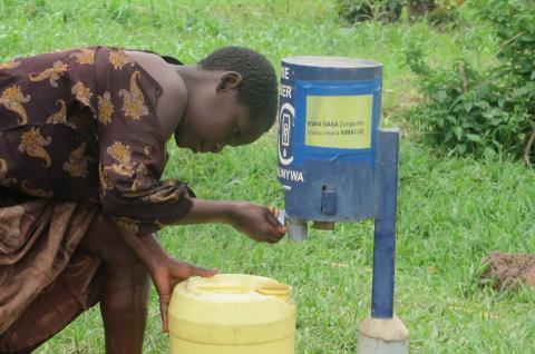 A child using chlorine dispenser in Kenya. © Thomas Chupein