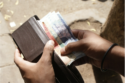 An individual counts Pakistani Ruppe in Karachi, Pakistan (Photo by Zeeshan Tejani on Unsplash)