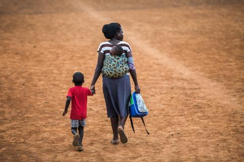 A woman walking with her children in Uganda