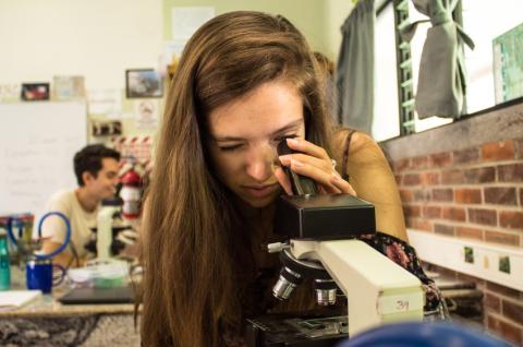 Girl looking through microscope