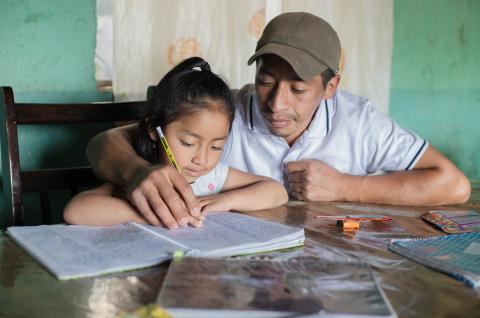 A father helps his girl with homework