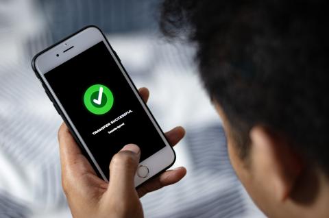 A man using his phone to transfer money