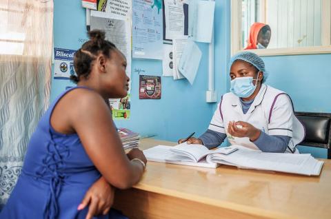 A pregnant woman attending a check-in with a healthcare provider in Kenya