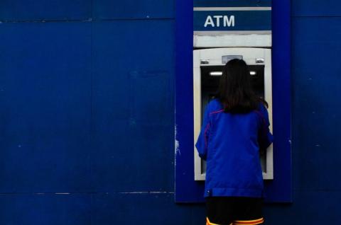 A woman enacting a transaction at an ATM in the Philippines.