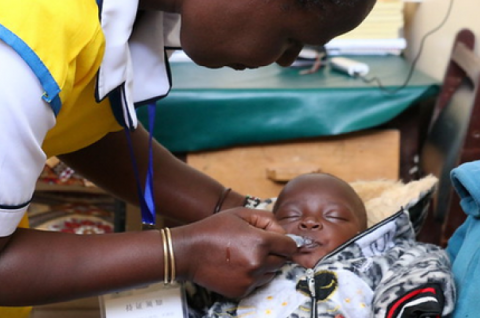 A health worker administering a vaccine to an infant. © USAID