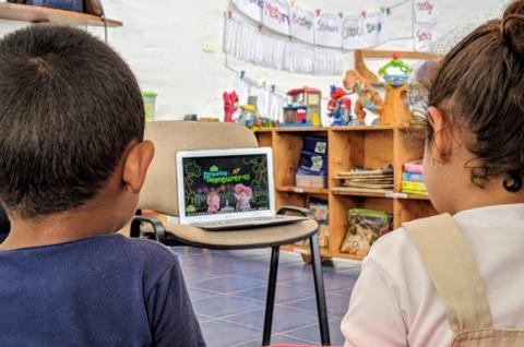Children sitting with their backs turned to the camera in a classroom in Colombia