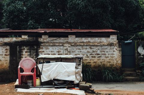 Photo of a chair and other old furniture bundled and stored outside on a street in front of a building. Credit: jeswin on Freepik