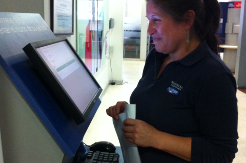 A woman using one of the kiosks at Chile Atiende. © Olga Fuentes, Jeanne Lafortune, Julio Riutort, Jose Tessada, Felix Villatoro