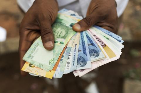 Hand holding various African bank notes