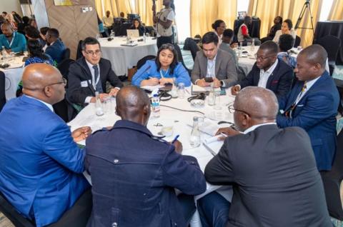 Participants sitting at a discussion table at the Cross-Country Learning Exchange Embedded Labs event in Kenya in 2025