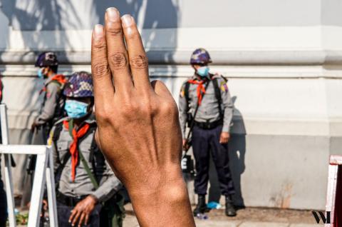 Protestor displays a pro-democracy salute in front of police officers in Yangon, Myanmar. © University of Yangon Students' Union