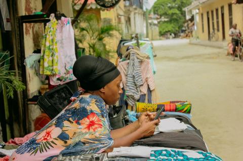 Female entrepreneur in Tanzania on her phone. © 2021 Paul Abraham on Unsplash