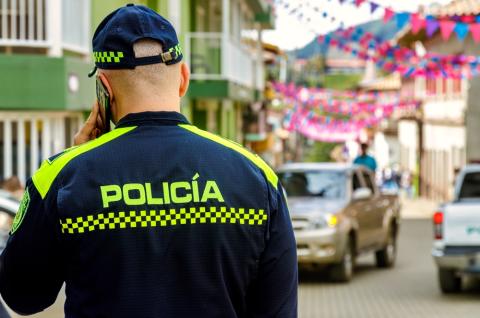 A Colombian police officer seen from behind while talking on the phone