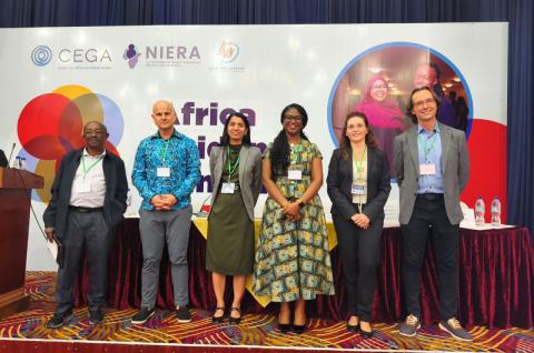 Dean and Claudia standing on stage with other panelists