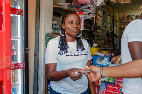 An African businesswoman receiving a cash payment. Photo by Ali Mkumbwa on Unsplash