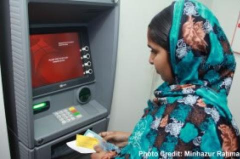 A woman using an ATM. © 2015 Minhazur Rahman